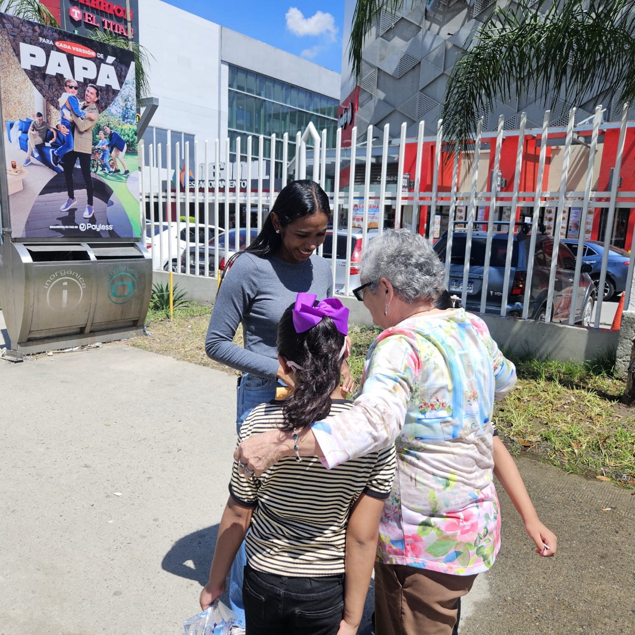 Rosa praying with a child and her family